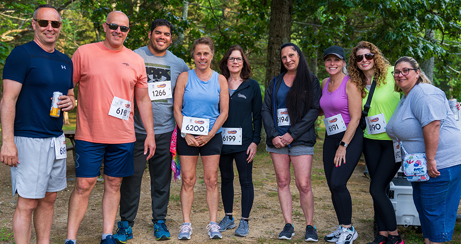 Industrial Coverage team members smiling and posing together at the charity run event.